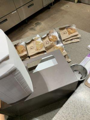 Empanadas labeled by hand in piles on the counter where customers can't get them.