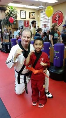 Master Tippett and Austin during his graduation.  He earned his Orange Belt.