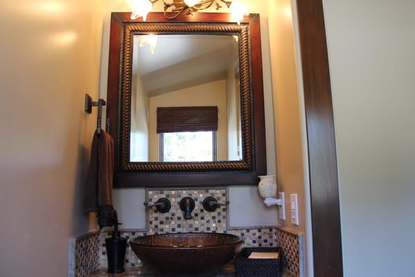 A small pocket bathroom looks great with the vessel sink and tile design.