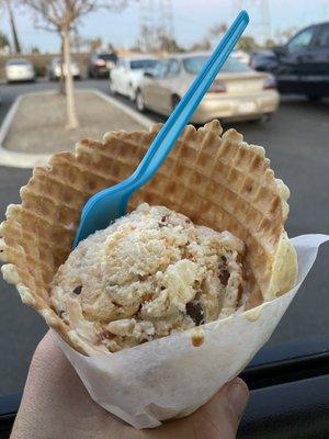 Butterfinger scoop in a freshly made waffle cone