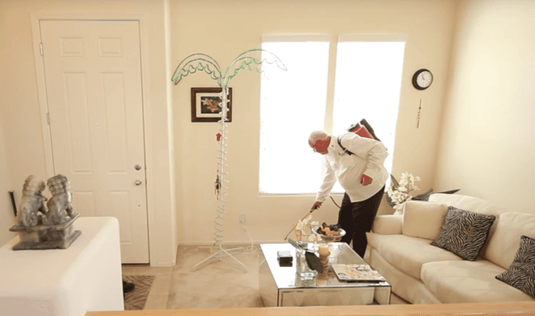 A pest control expert spraying a house - a cloud of mist and a spray of droplets surround the structure, as they combat unwanted invaders.