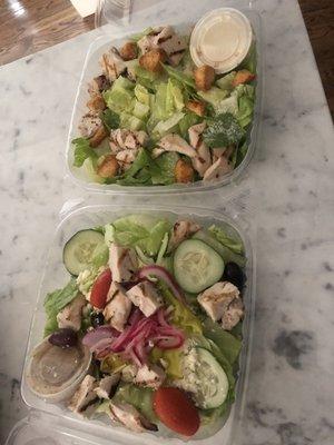 Greek salad and Caesar salad both with grilled chicken.