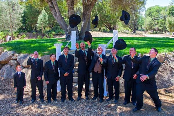 Groomsmen throwing their hats in the air.