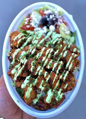 Tandoori chicken Basmati rice plate with a side of Greek salad topped with Herb sauce.