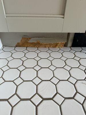 Ripped out wood exposing insulation under the sink.