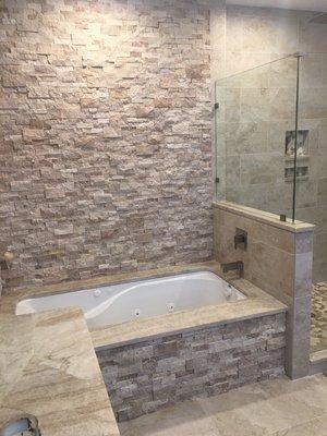 New jacuzzi tub with stone surround and quartz top.