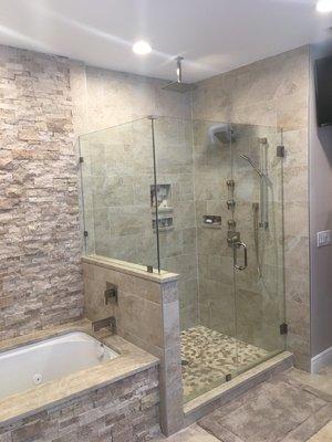 Tub and shower surround with frameless glass enclosure.