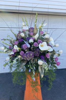 A purple and white custom designed sympathy arrangement . Done in  college school colors.