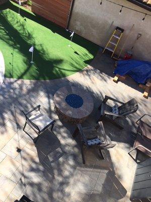 Fire pit, putting green and pavers.