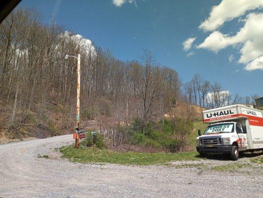 Where the uhaul trucks are located office top of gravel driveway two story blue garage