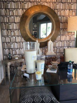 Candles, authentic shagreen building accessories, fish skinned upholstered side tables, large gold leaf mirror and cool wall paper.