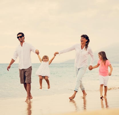 father, little daughter, mother, older daughter on the beach