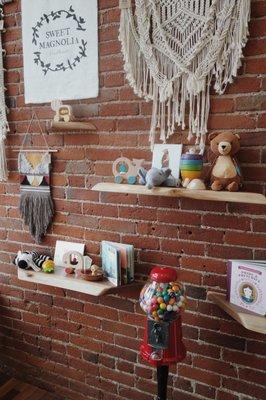 Our show wall featuring local handmade crochet animals and other toys we carry in the store for you to touch & feel.