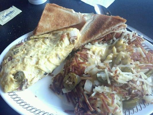 Fiesta omelet with covered, smothered, and peppered hash browns.