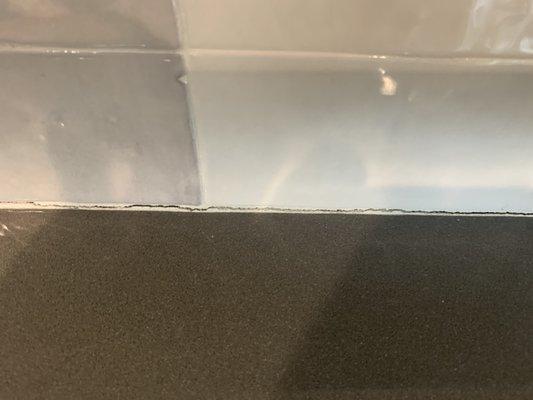 Backsplash installed without proper space with countertop causing cracking.