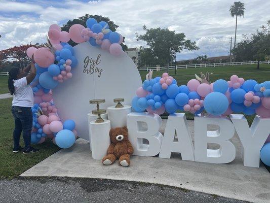 Gender Reveal Balloon Setup with baby table and teddy bear.