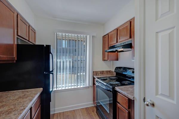 New wood floors and sleek black appliances in well appointed kitchens