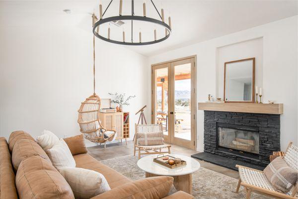 Living room with modern and very large chandelier. Our client painted the fireplace black. I think it turned out well!