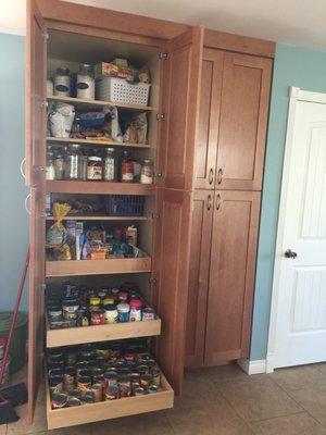 one pantry open with pull out drawers other pantry next to it.