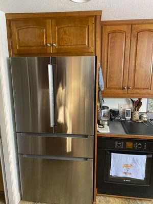 New cabinet above fridge matching 30-year old other cabinets.