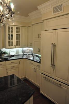 This kitchen sparkles with a crystal chandelier and a silver and white stripped backsplash.