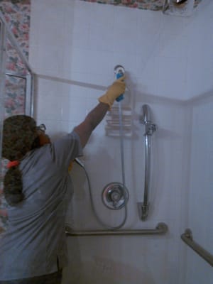 Team member Paulette polishing shower handle.