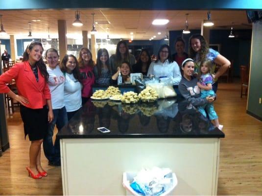 Pi Phi E sorority of Capital U volunteering by making rice crispy treats to bring some cheer for families using facility