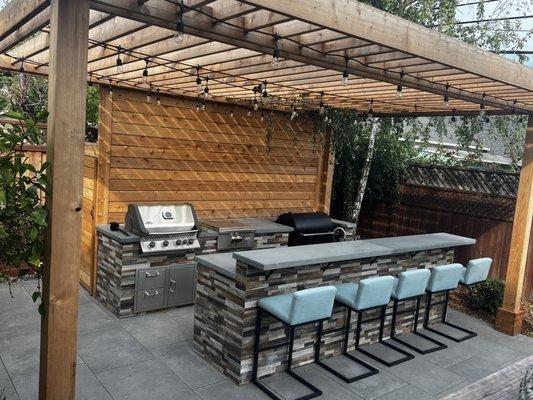 Custom kitchen, pergola, and built in shed behind the pergola.