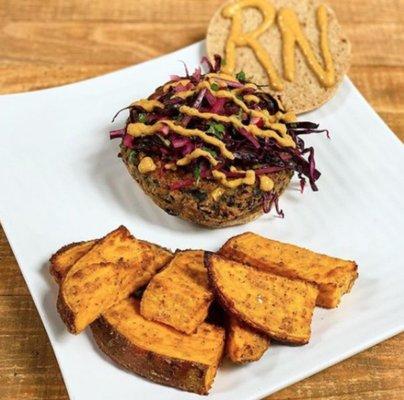 The Cancer Buster A scratch made black bean burger on a bun served with sweet potato wedges with a chipotle cashew mayo and a Mexican slaw.