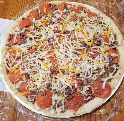 A pepperoni and beef pizza prior to baking