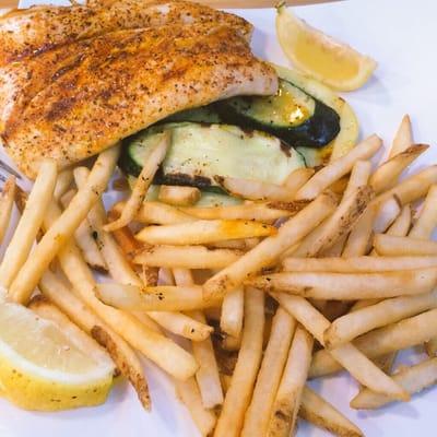 Mahi mahi marinated in Cajun seasoning with fries and grilled zucchini.