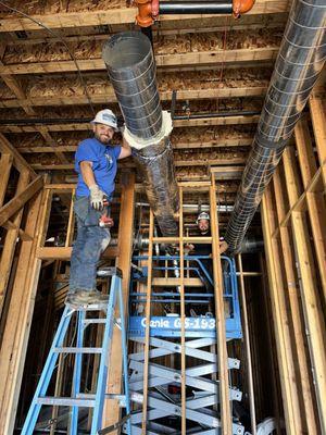 HVAC ductwork installation new construction site.