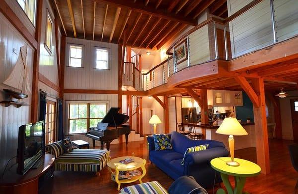 2 story Great Room featuring Timber Framing and exposed beams along with painted wood board interior walls.