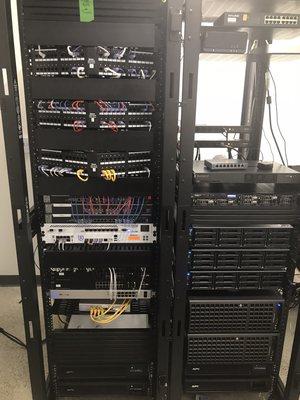 Server racks and gear all mounted and organized in new office space.