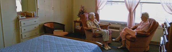 Resident enjoying a visit with family in her room.