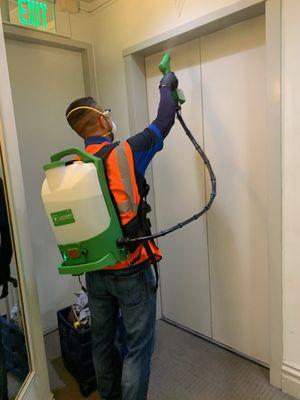 Our team providing backpack electrostatic disinfecting at elevator