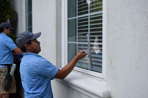 Service Technician cleaning a window.