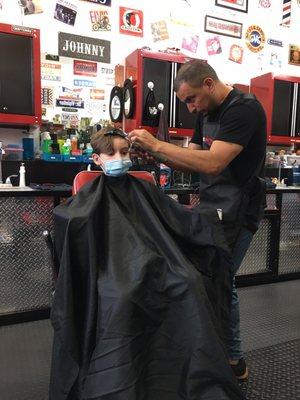 My son getting his haircut from the amazing barber, Johnny.