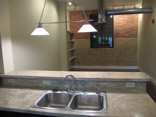 Open floor plan spaces with brick walls and stained concrete floors