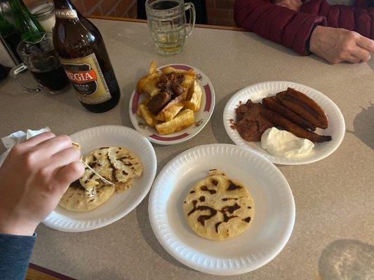 Pupusas revueltas, yucca con chicharrón, plátano frito con frijol y crema.