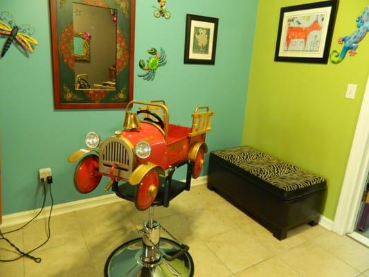 Cute children's styling chairs for haircuts.  Each station is fully equipped with a television for entertainment.