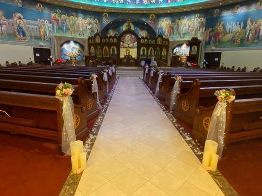 The aisle is decorated and ready for the bride, groom, and wedding party.