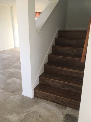 Wood on stairs, porcelain tile below.