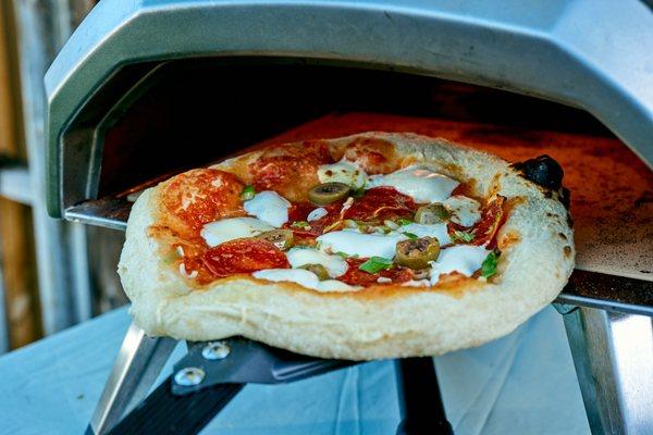 We use Ooni ovens, so your pizza expirience can be outdoors with this portable ovens!