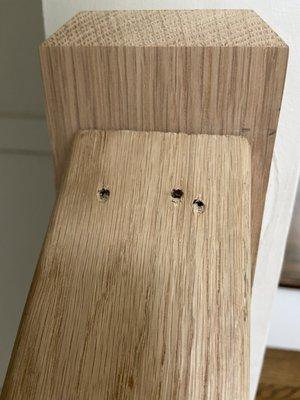 unsightly nail holes on banister railing, left unfinished or repaired