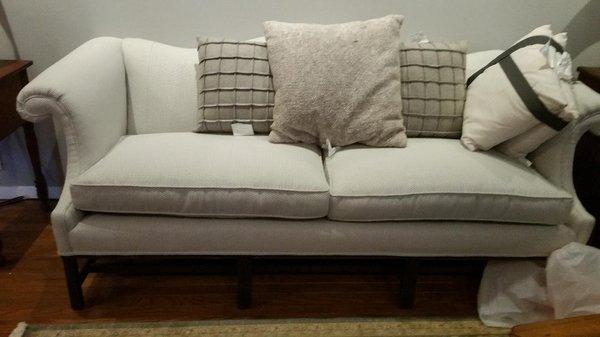 Light blue upholstered couch with custom pillows.