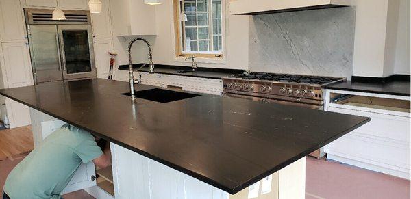 A marine black island piece with the super white quartzite as a backsplash.