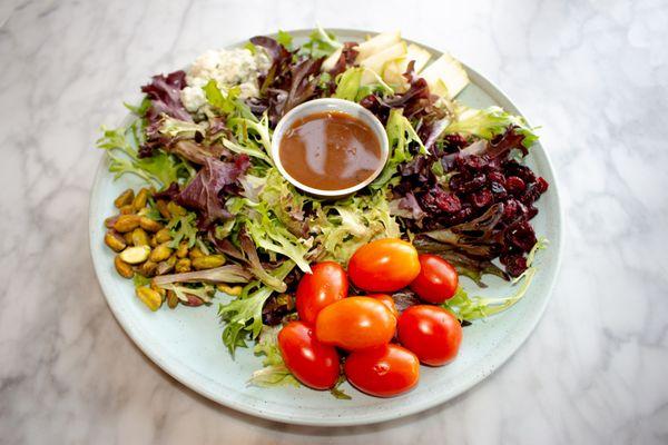 Signature Salad  Ingredients: spring mixed greens, pears, tomato, dried cranberries, pistachios, blue cheese, sherry shallot vinaigrette