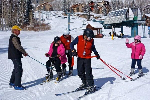 Local school groups learning to ski with the help of tethers and ski bikes