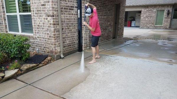 Pressure washing a driveway for a customer